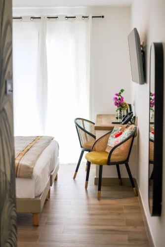 a bedroom with a bed and a desk with a chair at Le Saint Erasme, Hotel Eco Friendly in Calvi