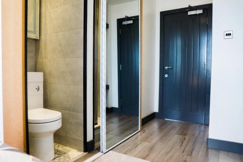 a bathroom with a toilet and a mirror at Cozy Retreat in the Heart of Liverpool in Liverpool