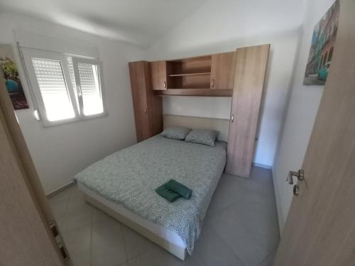 a small bedroom with a bed and a window at Apartment with a pool mountainview near the sea! in Posedarje
