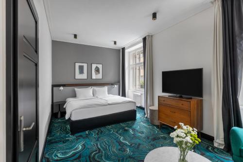a hotel room with a bed and a flat screen tv at numa I Republika Rooms & Apartments in Prague