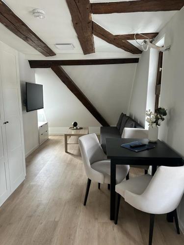 une salle à manger avec une table noire et des chaises blanches dans l'établissement Ochsen-Durlach, à Karlsruhe