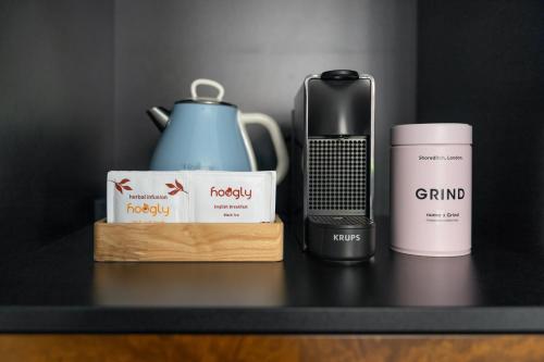 a table with a coffee maker and a bottle of coffee at Numa Prague Republika in Prague