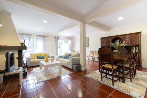 a living room with a table and a dining room at Furnas Millhouse in Furnas