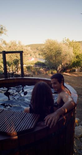 a man and a woman sitting in a hot tub at Quinta do Benjamim - Tejo "For 2, family, nature or relax" in Praia do Ribatejo