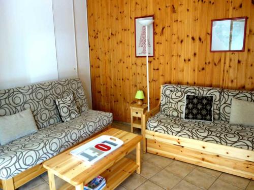 ein Wohnzimmer mit einem Sofa und einem Couchtisch in der Unterkunft Appartement Avec Balcon in Vars