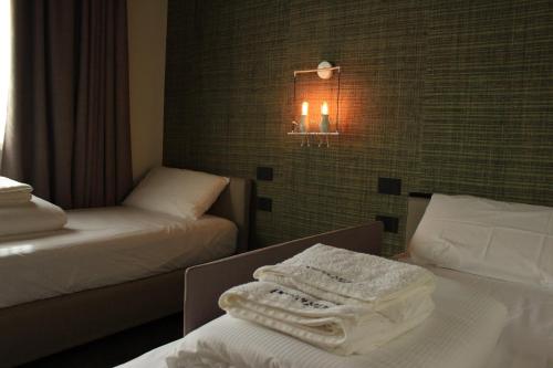 a hotel room with two beds and a light on the wall at Tenuta Pezzapane in Alvignanello