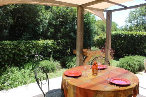 une table avec des plaques rouges placées sous un parapluie dans l'établissement CASA PALOMBAGGIA - Piscine Chauffée, à Porto-Vecchio