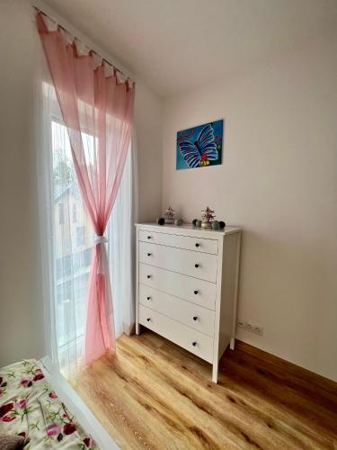 a bedroom with a dresser and a window at Apartmán Roda2 Malé Lipno in Černá v Pošumaví