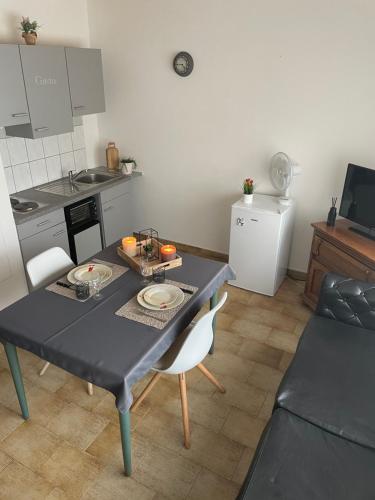 a living room with a table and a kitchen at Charmant studio in Binche