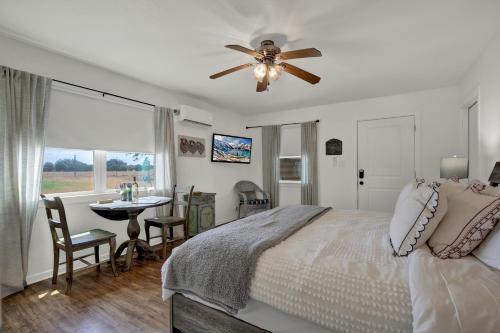 um quarto com uma cama, uma ventoinha de tecto e uma mesa em Cozy Casita! In Texas Famous 290 Winery Corridor! em Stonewall