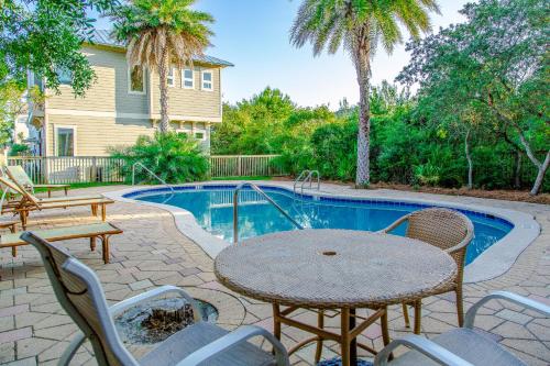 a patio with a table and chairs next to a pool at Where The Sidewalk Ends in Inlet Beach