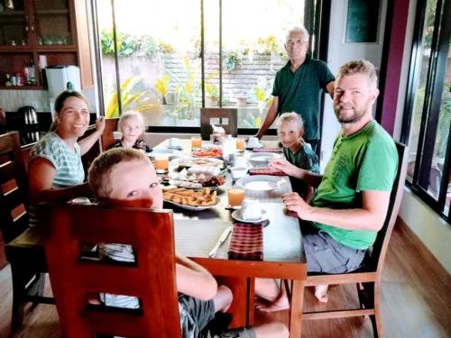 a family sitting at a table with a meal at The Tenthola in Kandy