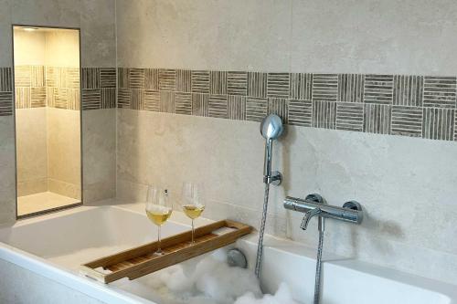 a bath tub with two glasses of wine at Residenz an der Ostsee in Scharbeutz