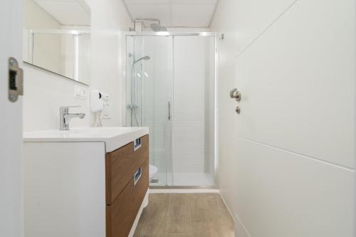 ein Bad mit einer Dusche und einem Waschbecken in der Unterkunft Suite Homes Hesperides garden beach in Málaga