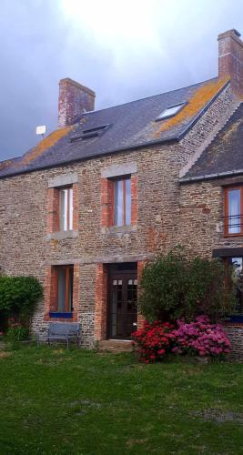 une maison en briques avec des fleurs devant elle dans l'établissement Gîtes des Archanges, à Macey