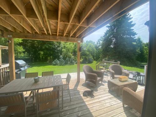 a patio with a table and chairs on a deck at Centre Gate House Licence# 117-2023 in Niagara-on-the-Lake