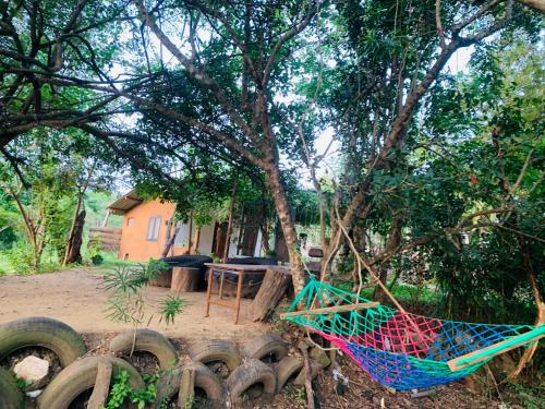 a hammock hanging from a tree in front of a house at Thanamal-villa in Tanamalwila