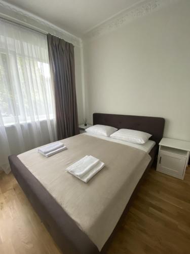 a bedroom with a large bed with towels on it at Petro Apartamentai in Kačerginė