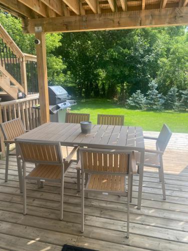 uma mesa de madeira e cadeiras num deque em Centre Gate House Licence# 117-2023 em Niagara-on-the-Lake
