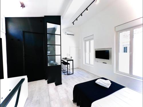 a white bedroom with a black door and a desk at Suite in the City - Standing Hyper-centre JACUZZI CLIM WIFI in Montpellier