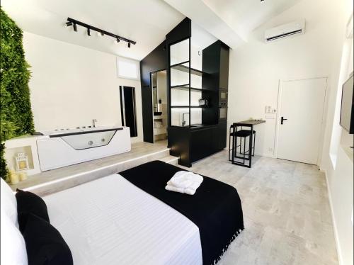 a bedroom with a large bed and a bath tub at Suite in the City avec JACUZZI PRIVATIF - Hyper Centre in Montpellier