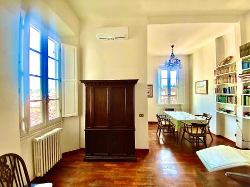 - un salon avec une table, des chaises et des fenêtres dans l'établissement Casa Pavó Appartamento accanto al Bargello, à Florence