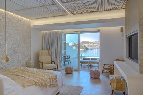 a bedroom with a bed and a view of the ocean at Icon Mykonos in Megali Ammos