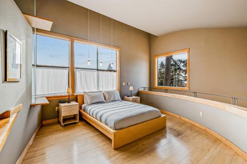 a bedroom with a bed and two windows at Madrona Tree Retreat in Coupeville