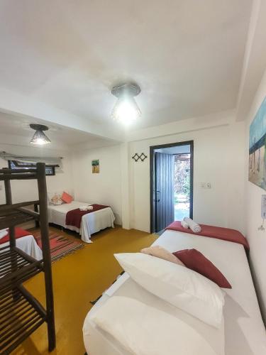 a bedroom with two beds and a bunk bed at Pousada Raiz Forte in Caraíva