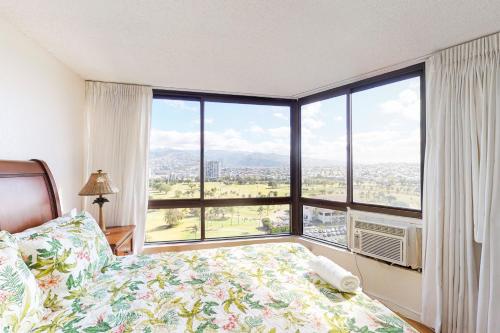 ein Schlafzimmer mit einem Bett und einem großen Fenster in der Unterkunft Monte Vista 1704 in Honolulu
