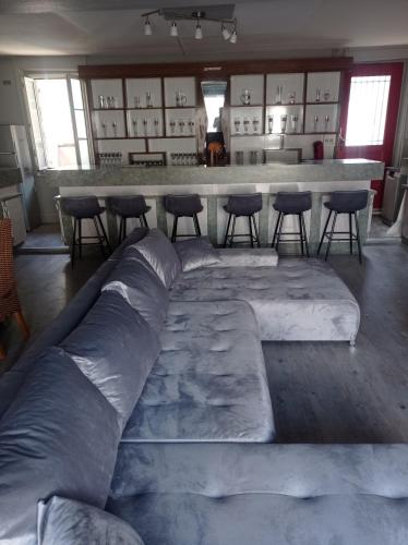 a large couch in a room with a bar at Le café des vacances in Pierre