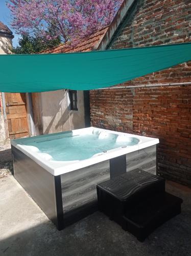 a hot tub in a brick building with a blue canopy at Le café des vacances in Pierre