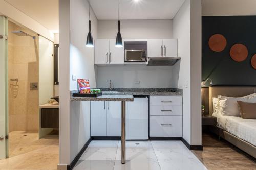 a kitchen with white cabinets and a table in a room at Soy Local Usaquen in Bogotá