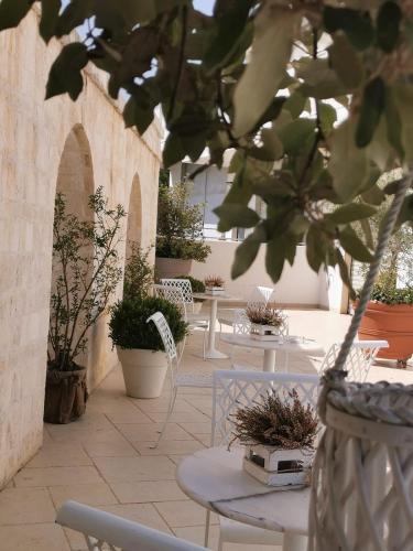 a patio with tables and chairs and potted plants at B&B Le Torri in Santeramo in Colle