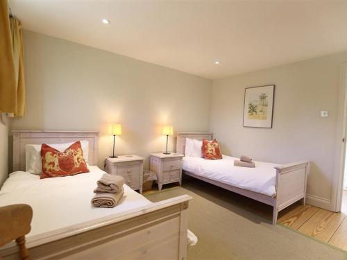 una camera con due letti e due comodini di The Granary a Cheltenham