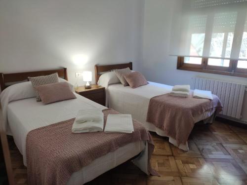 a bedroom with two beds with towels on them at Celia in Redondela