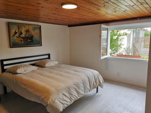 a bedroom with a large bed with a window at Appartement Le Maro in Saubusse