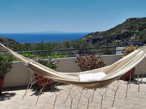 a hammock on a balcony with a view of the ocean at Amphithea Fragokastelo-Skaloti in Skalotí