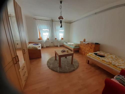 a living room with two beds and a table in it at Menedék - testnek és léleknek 