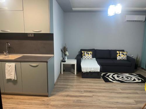 a kitchen and a living room with a couch at Guest House Amaya Med in Plovdiv