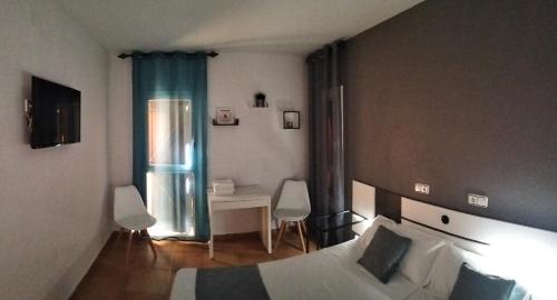 a hotel room with a bed and a table and chairs at Hostal Turbon in Campo