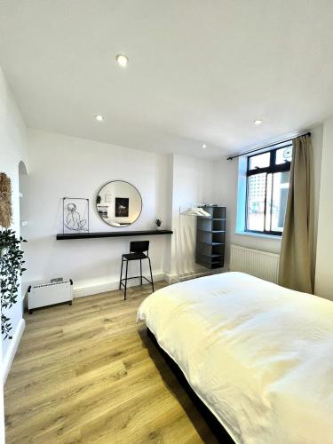 a bedroom with a large bed and a mirror at Bright & Spacious 1 bed steps from Hyde Park in London