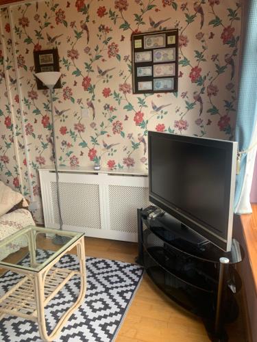 a living room with a flat screen television on a wall at Beech Lodge B&B in Lisheenanoran