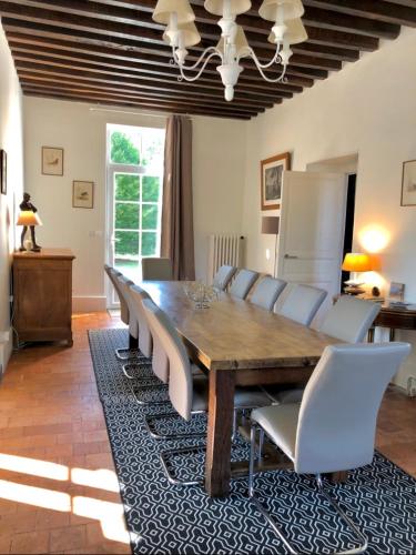 a dining room with a wooden table and chairs at DOMAINE DE MALVAUX - Gîte classé 5 étoiles - 15 personnes - Sologne - Nouan le Fuzelier - Ambassadeur Sologne in Nouan-le-Fuzelier