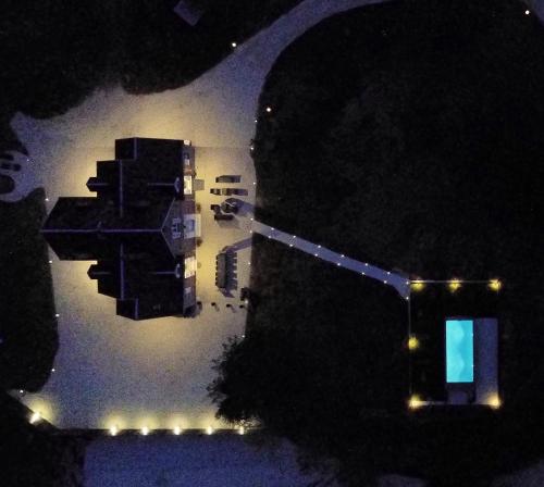 an aerial view of a building at night with lights at DOMAINE DE MALVAUX - Gîte classé 5 étoiles - 15 personnes - Sologne - Nouan le Fuzelier - Ambassadeur Sologne in Nouan-le-Fuzelier