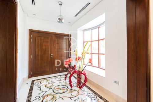a hallway with a door and a vase with flowers at آلمعترض in Al Ain