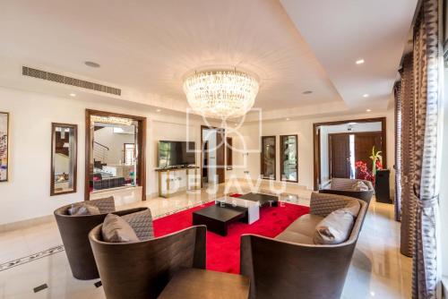 a living room with a chandelier and a red rug at آلمعترض in Al Ain