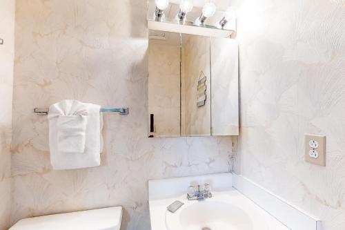 a bathroom with a sink and a toilet and a mirror at Island Sands 306 in Fort Walton Beach