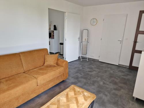 un salon avec un canapé et une table dans l'établissement Appartement 2 adultes / 1 enfant, à Dompierre-sur-Besbre