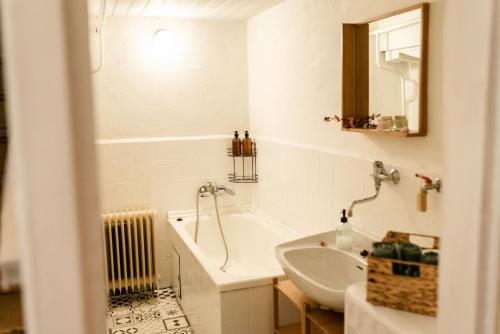 a white bathroom with a tub and a sink at Chalupa pod vysokou in Ludvíkov